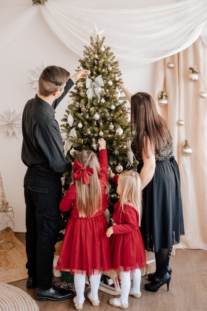 Család közösen díszíti a karácsonyfát a stúdióban